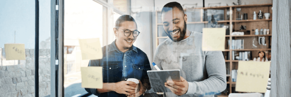 Program leaders collaborating around a laptop, representing practical support, governance, and enablement.