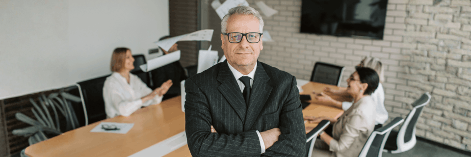 Senior professional addressing a leadership team, representing calm, experienced, and independent executive advisory.